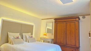 Ein Hotelzimmer mit Bett, Schreibtisch, Spiegel und Kleiderschrank.