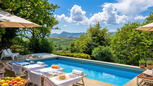 Un espace piscine équipé de chaises longues, de parasols et offrant une vue sur la campagne.