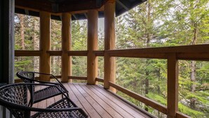 A wooden deck with a view of a forest. - Ski in/out | BBQ | Complex pool & Hot tub | Garage (Whistler)