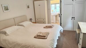 A hotel room with a bed, a wardrobe, a desk, and a bathroom visible through an open door. - "Wonderfully Situated in the heart of Exmoor" (Exford)