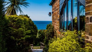 A stone building with large windows overlooking the ocean.