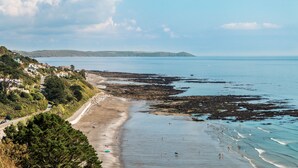 A coastal beach with rocky areas and a clear view of the sea.
