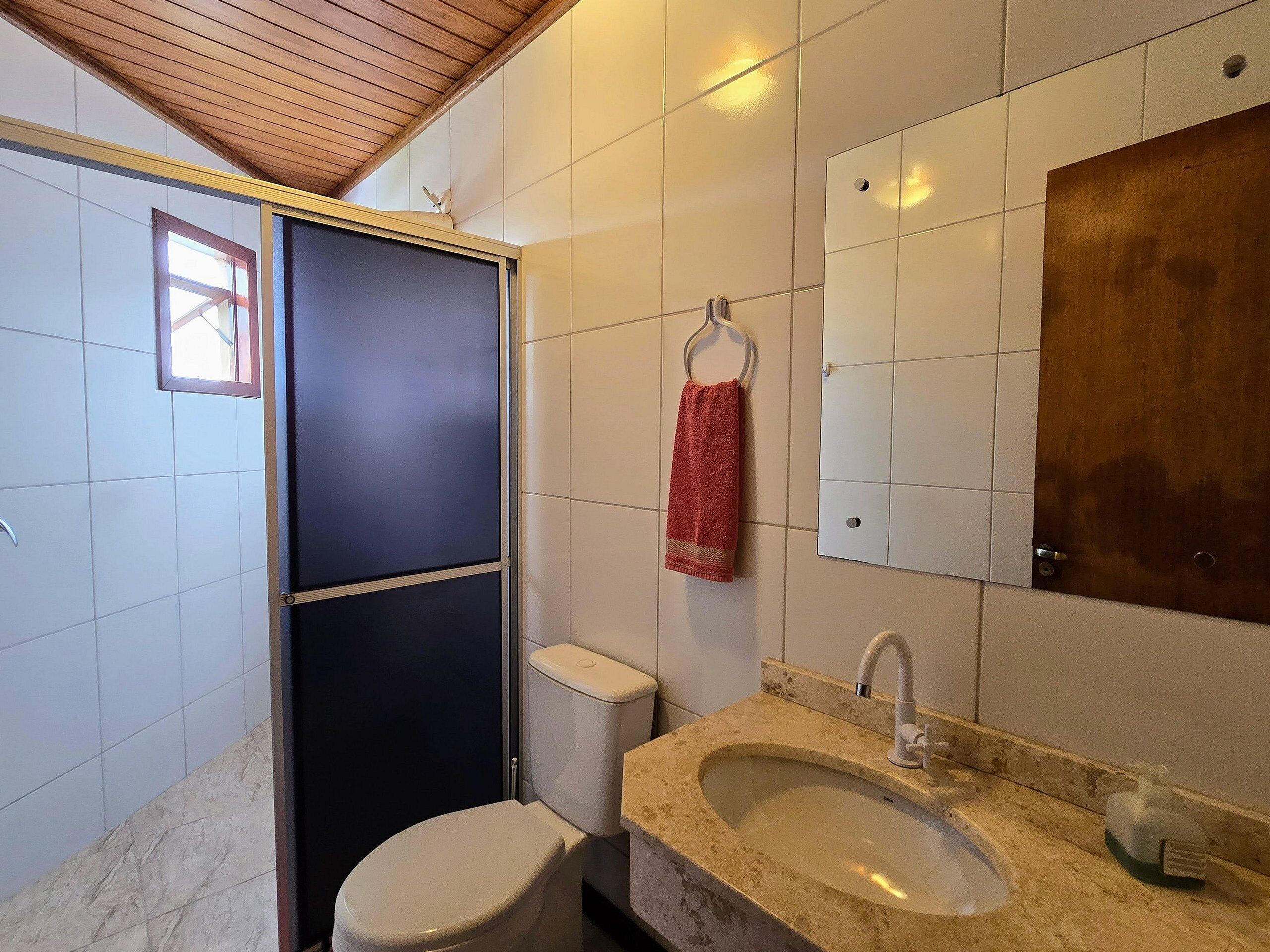 A bathroom with a toilet, sink, and mirror.