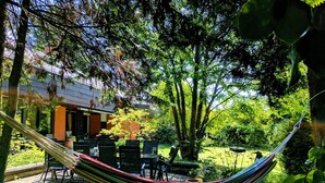 Un'amaca in un giardino rigoglioso, con un patio e mobili da esterno.