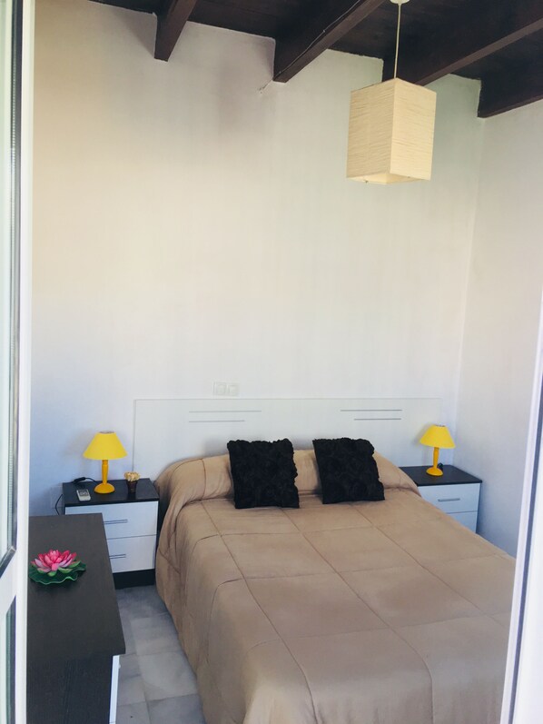 A bedroom with a bed, two bedside tables with lamps, a nightstand, and a hanging light fixture. - WONDERFUL ATTIC IN TRIANA / CENTRO BRIDGE WONDERFUL PENTHOUSE BRIDGE TRIANA / CENTER (Sevilla)