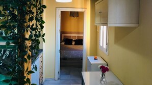 Una habitación con cama, mesita de noche y lámpara colgante.