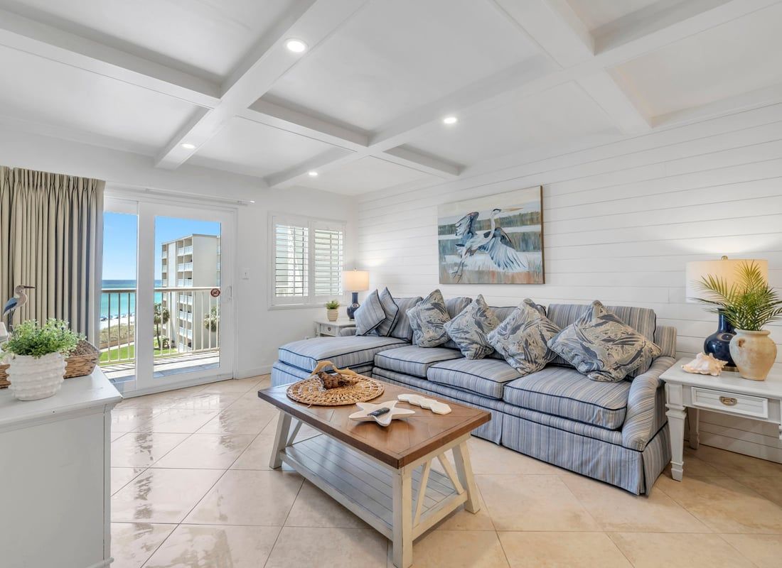 A modern living room with a sectional sofa, a coffee table, and a view of the outside.