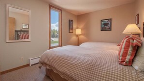 A bedroom with two beds, a window, a mirror, and wall art. - JHRL - Mtn Alder 824, A cozy 2 bedroom condominium located in The Aspens (Wilson)