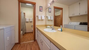 A bathroom with a sink, mirror, towel rack, and a washing machine. - JHRL - Mtn Alder 824, A cozy 2 bedroom condominium located in The Aspens (Wilson)