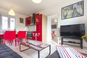 Eine moderne Wohnung mit Küche, Essbereich, Wohnzimmer und Fernseher.