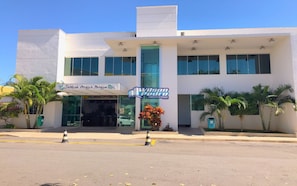 A modern building with a storefront labeled "Jardins Acqua Parque" and "Wilson Pedro Corretores de Imóveis."