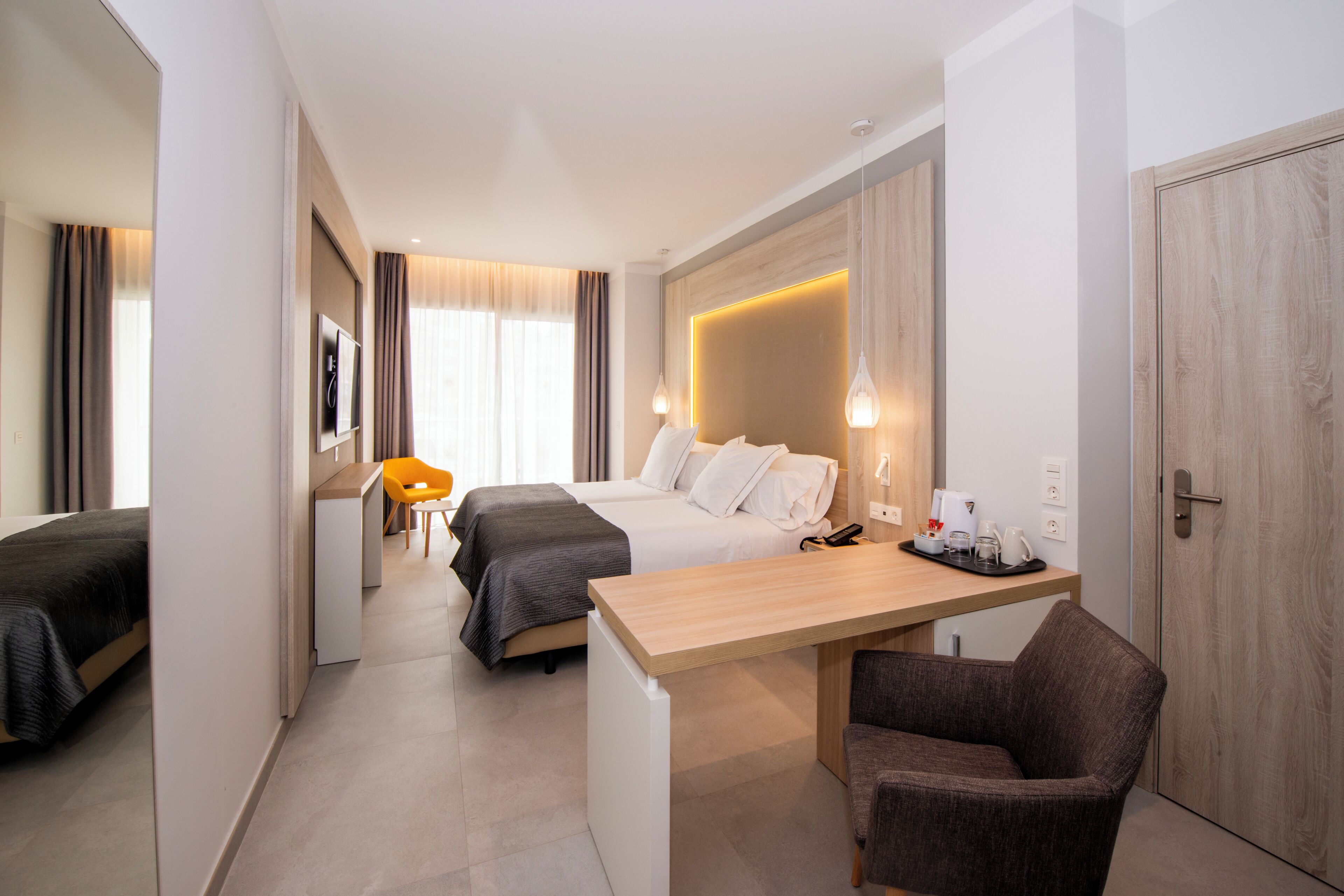 Une chambre d’hôtel équipée d’un lit, d’un bureau, d’une chaise et d’une petite kitchenette.