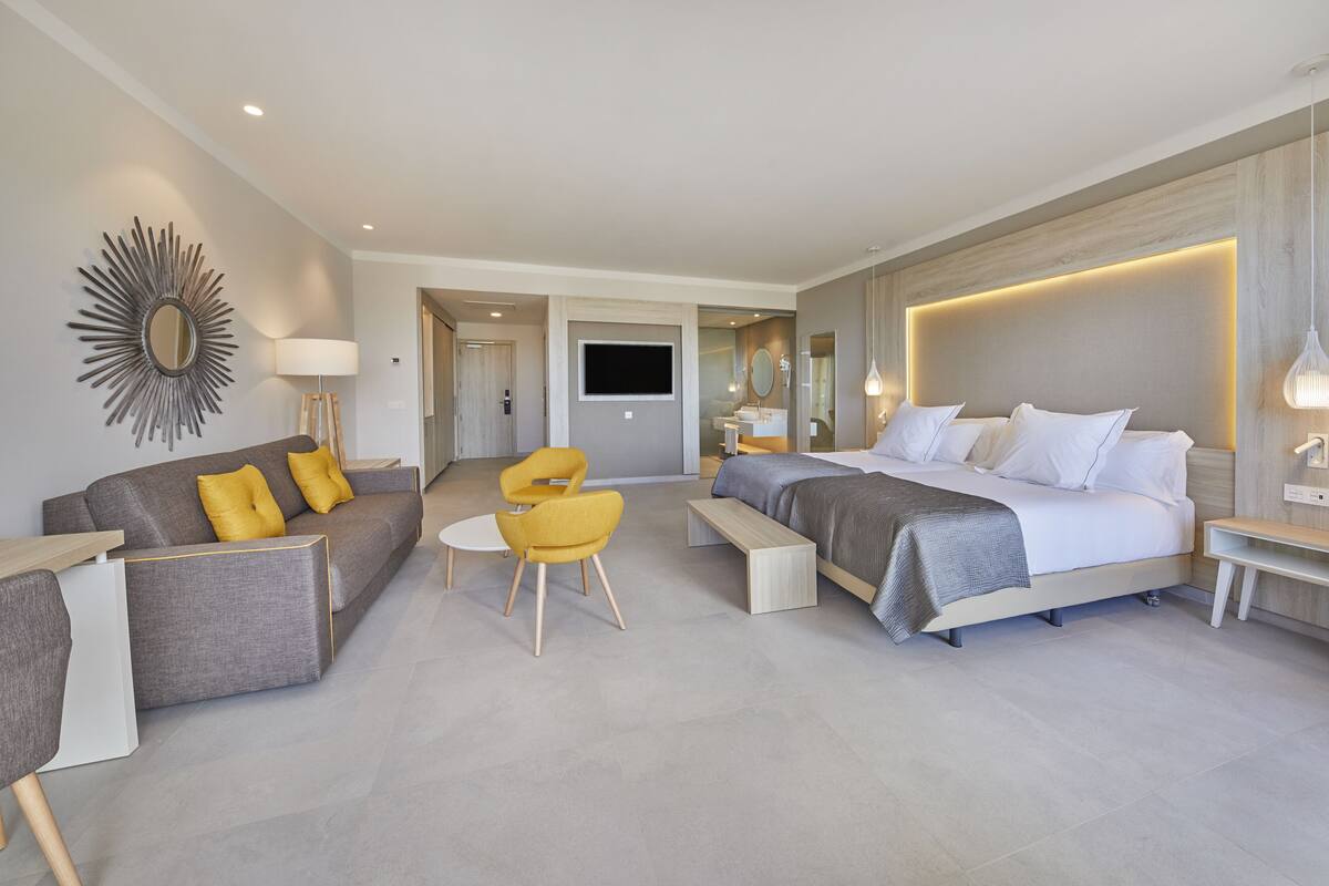 Une chambre d’hôtel moderne équipée d’un canapé, d’un lit, d’un bureau et d’une chaise.