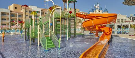 A water park with slides and a castle-like structure in the background.