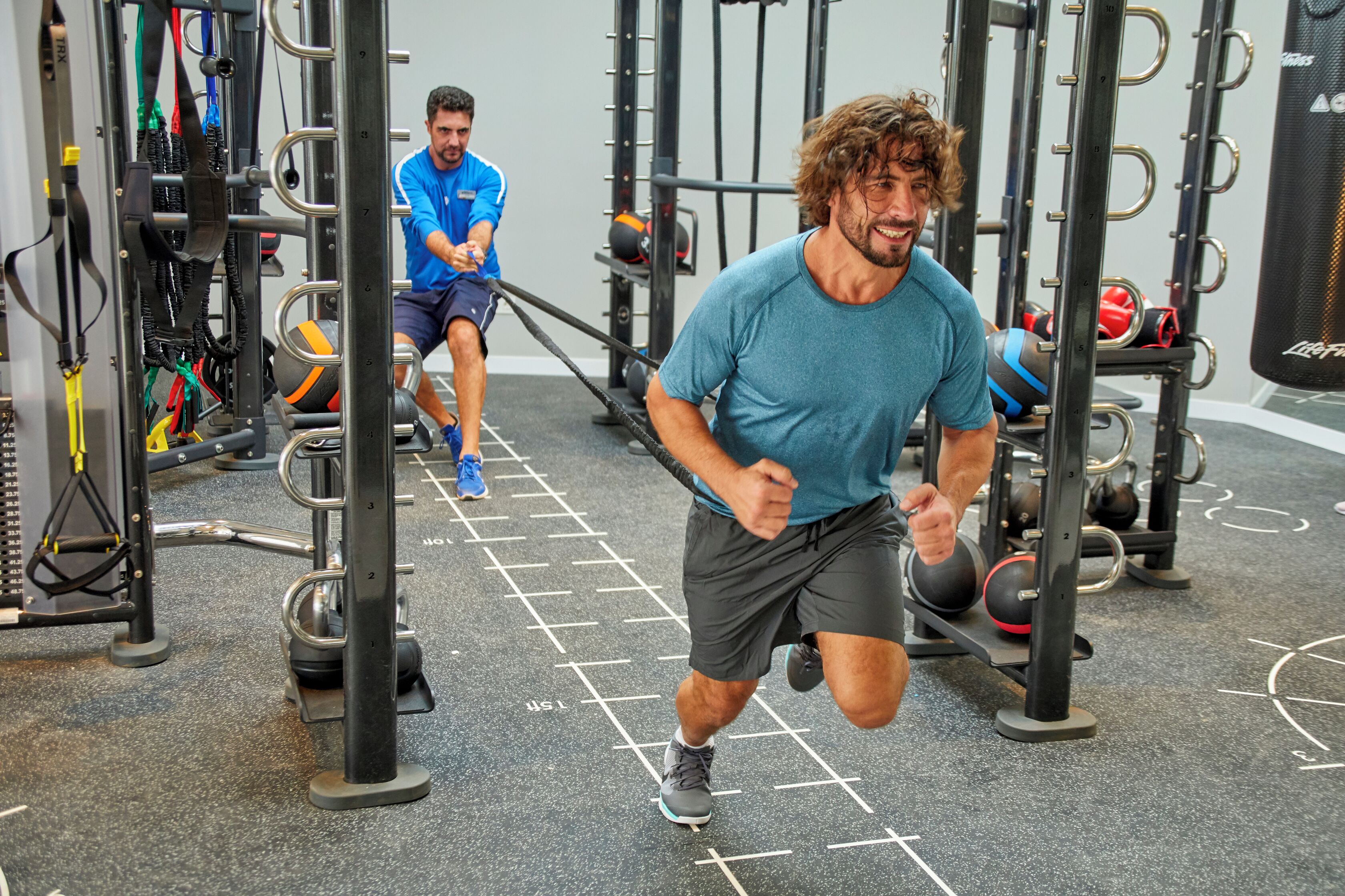 A gym with exercise equipment and a person running.