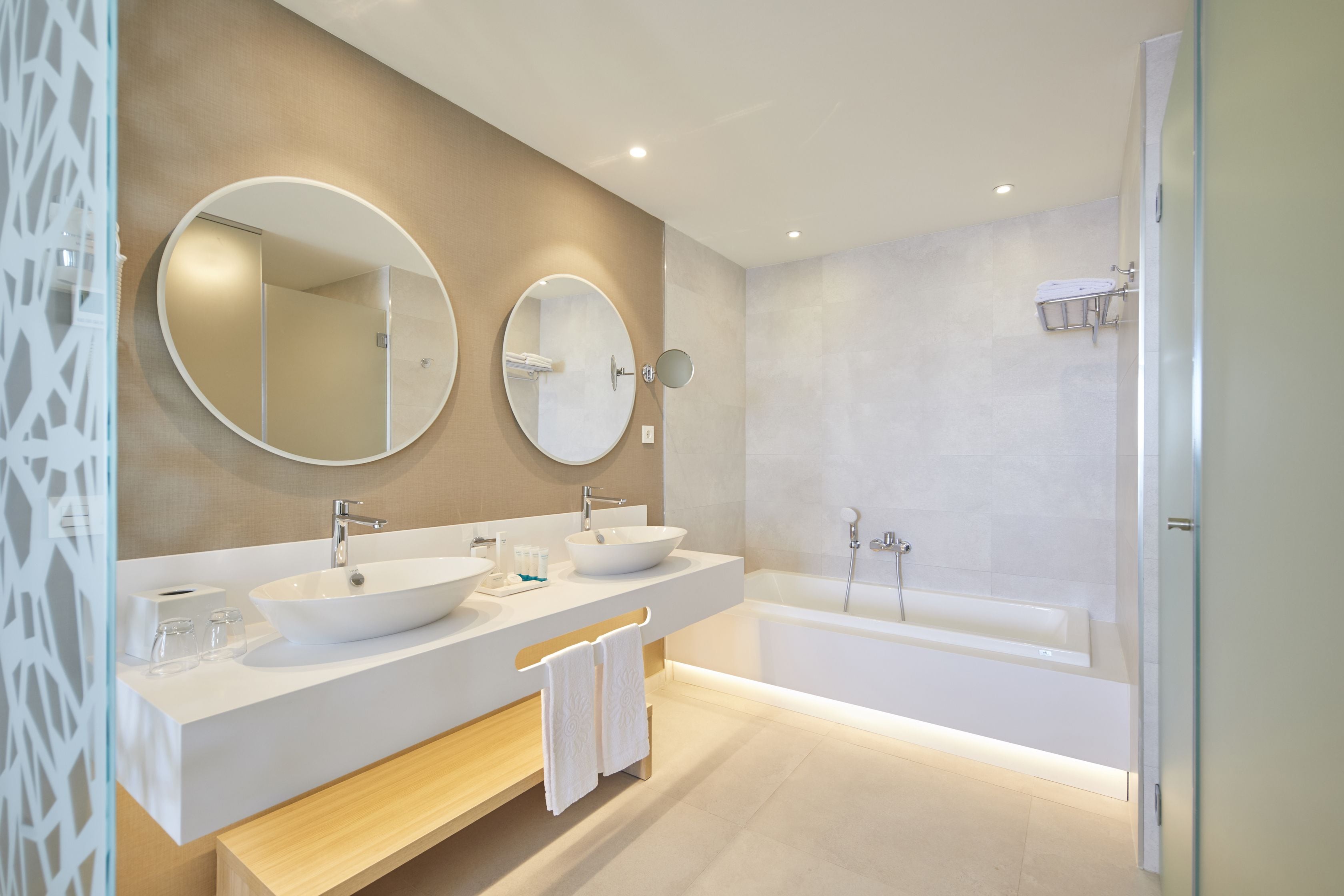 Ein modernes Badezimmer mit zwei Waschbecken, einer Badewanne und zwei großen Spiegeln.