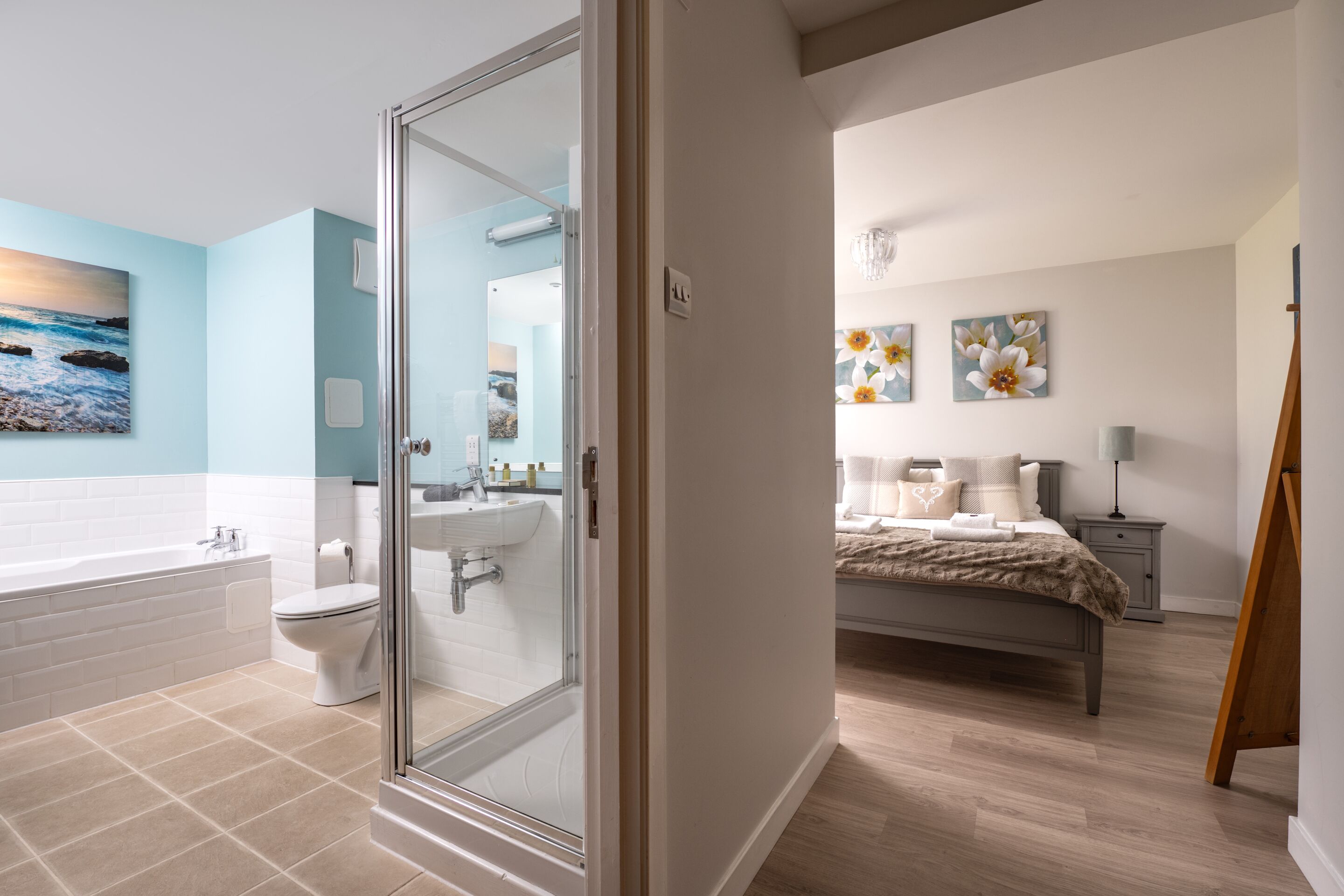 Un baño moderno con cabina de ducha de vidrio, una bañera blanca y un inodoro.