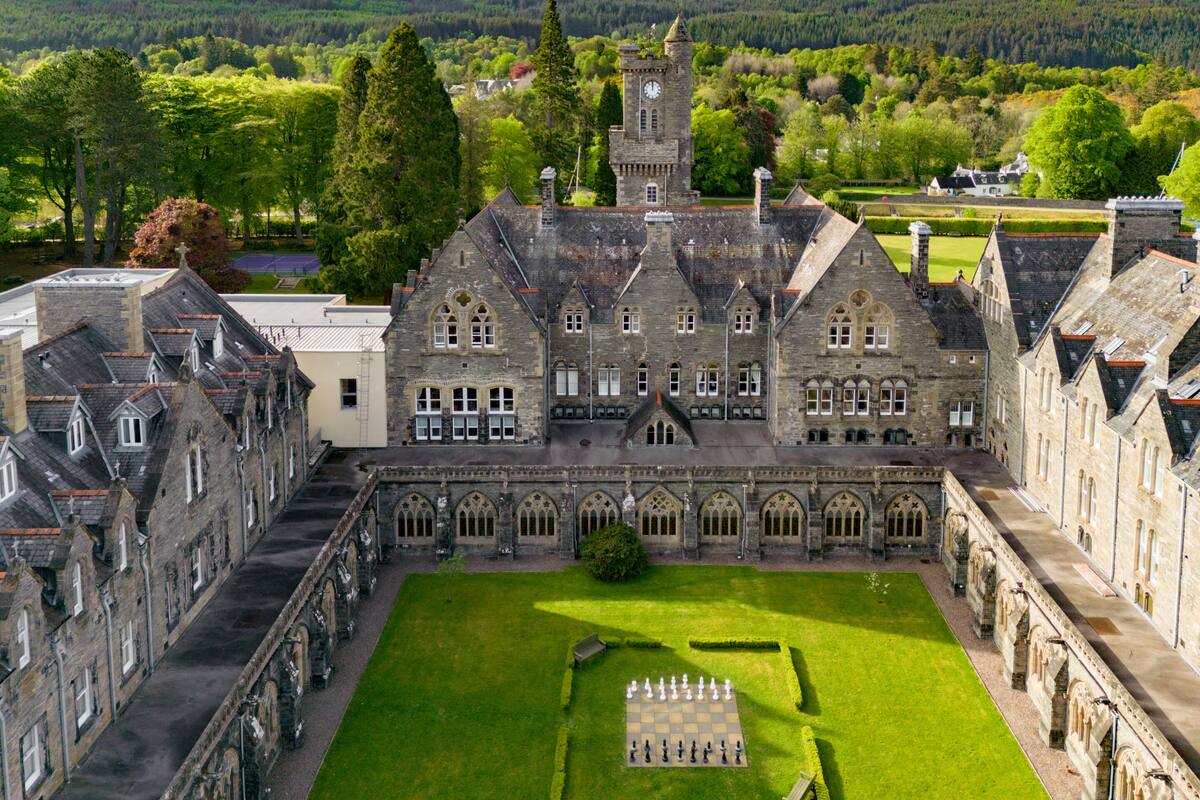 A historic building with a central courtyard featuring a chessboard.