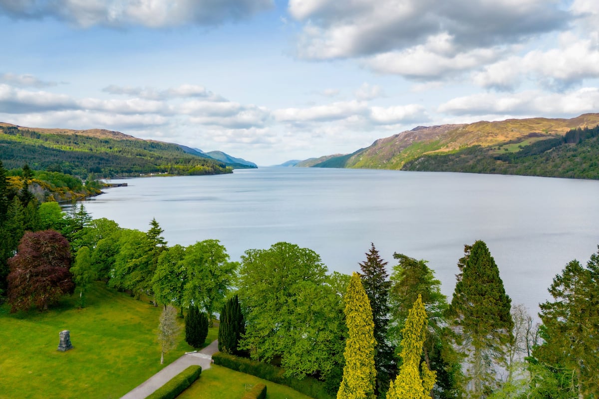 A lake surrounded by lush greenery and hills.