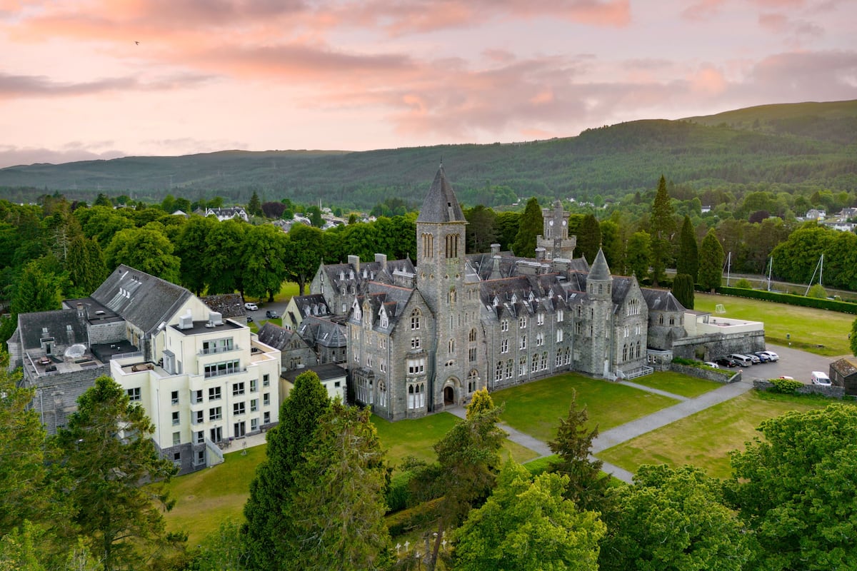 A large, historic building with multiple towers and a central courtyard.