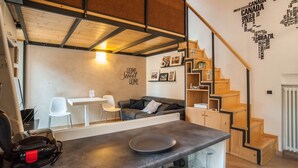 A compact living space with a kitchenette, a dining area, a sofa, and a staircase. - DELICIOUS LOFT TO SAN PIETRO (Roma)