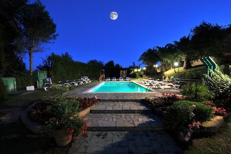 Una piscina al aire libre de temporada, sombrillas