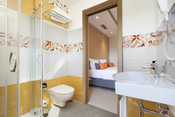 A modern bathroom with a glass shower enclosure, a white toilet, and a sink with a mirror. - Hotel O Sole Mio (Massa Lubrense)