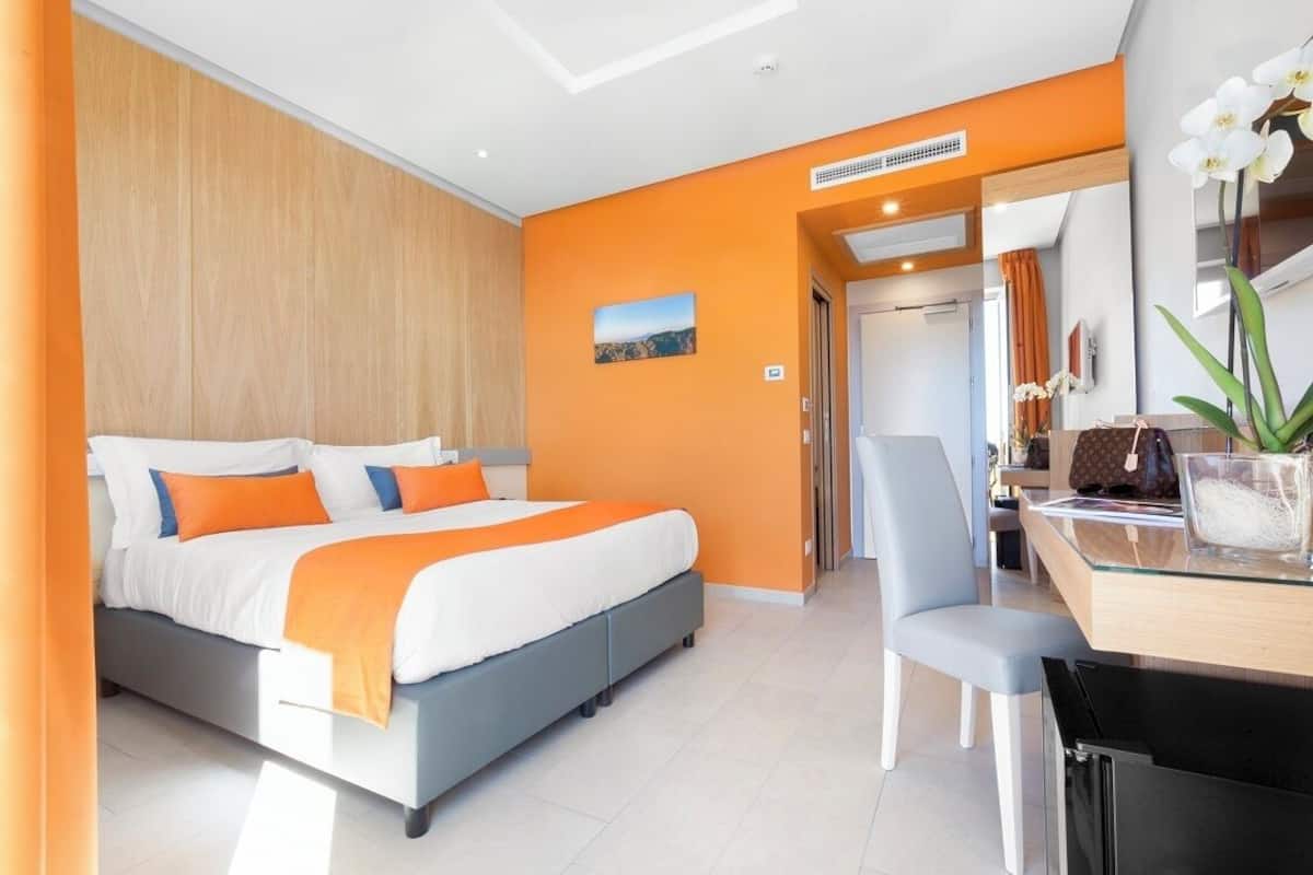 Una habitación de hotel moderna con una cama, un escritorio y una silla.