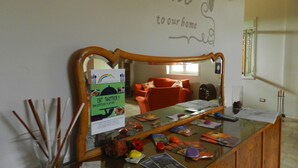 A reception desk with a mirror, a welcome sign, and a bulletin board with a menu.