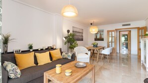 Un salon moderne avec un canapé, une table basse et un coin repas.