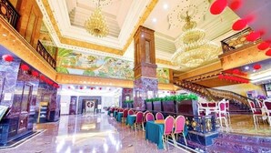 A grand hall with a marble floor, a staircase, and a balcony with red lanterns. - Nanyang Seascape (Zhuhai)