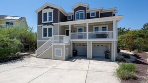 A two-story house with a front porch, a garage, and a staircase leading to the second floor. - Beautiful, large home in Cape Shores! (Lewes)