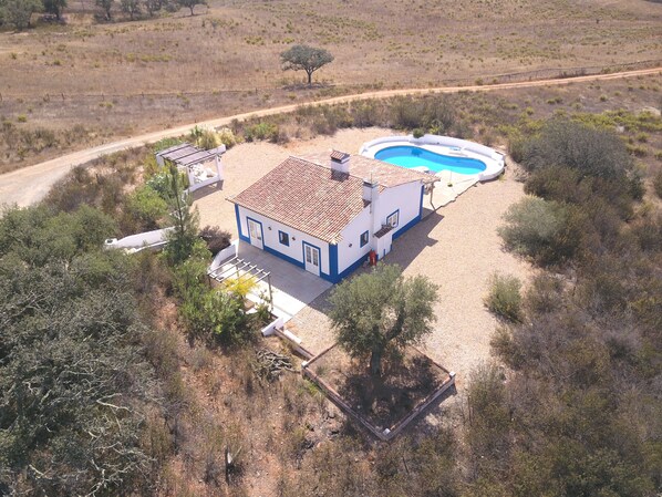 A house with a swimming pool, surrounded by dry vegetation and a dirt road. - Secluded 2 Bedroomed Country Cottage with Private Pool north of the Algarve (Garvao)