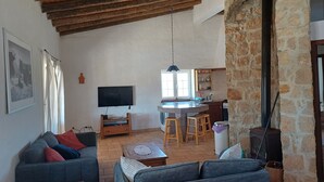 A cozy living room with a grey sofa, a wooden coffee table, and a TV mounted on the wall. - Secluded 2 Bedroomed Country Cottage with Private Pool north of the Algarve (Garvao)