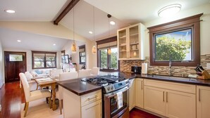 A modern kitchen with a central island, built-in cabinets, and a large window providing natural light.