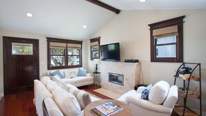 A living room with a fireplace, a television, and a bookshelf.