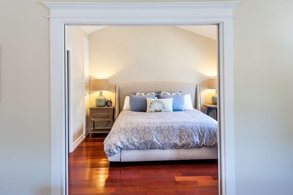 A bedroom with a large bed, two bedside tables, and a nightstand.