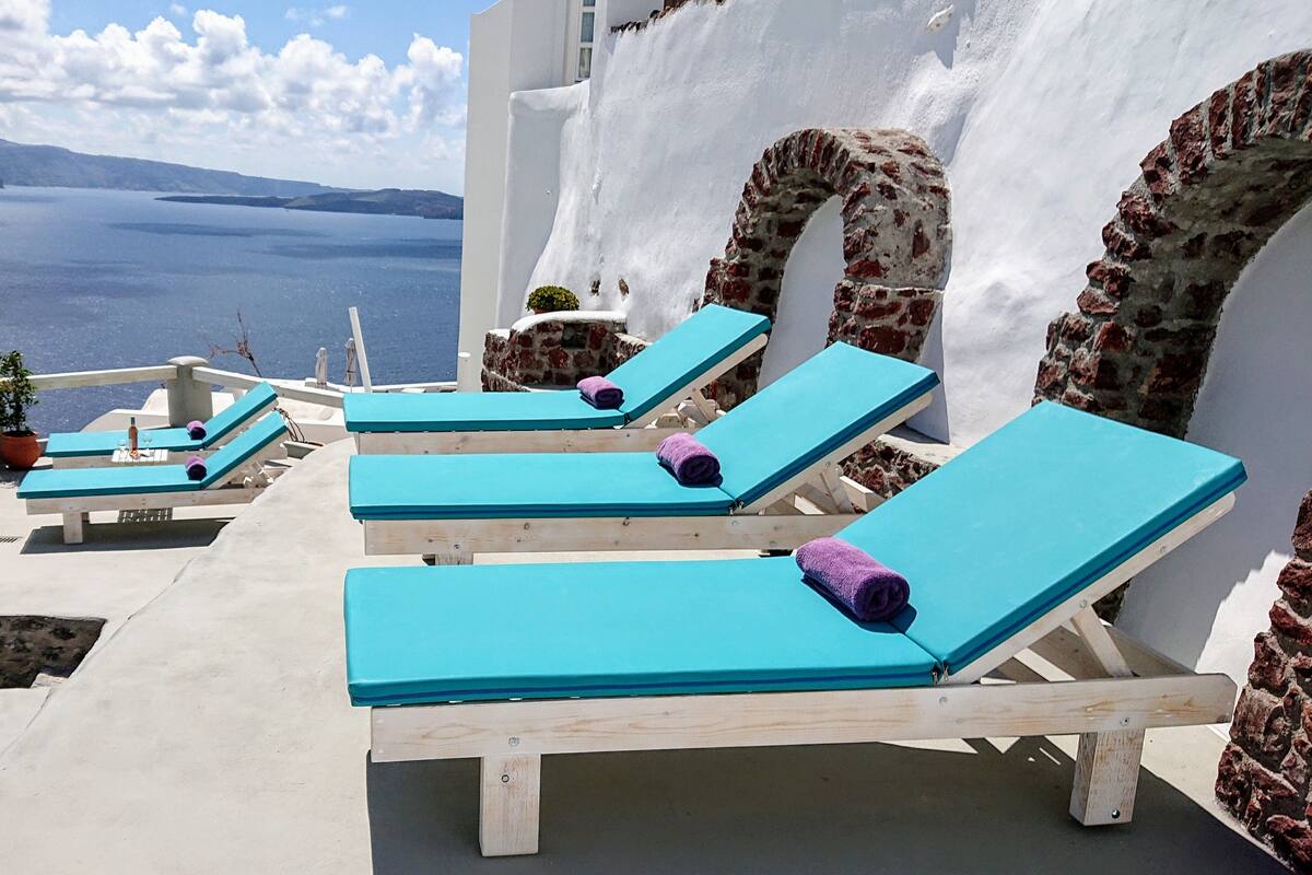 A seaside terrace with lounge chairs and a view of the sea.