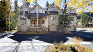 A two-story house with a front porch, garage, and a driveway leading to the entrance.