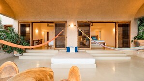 A spacious room with a large bed, wooden furniture, and a hammock. - Luxe Beach Villa in Exclusive Oceanfront Community (Huatulco)