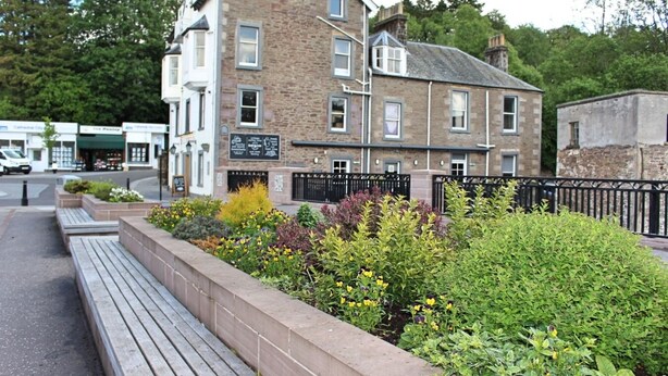 A stone building with multiple windows and a black metal fence. - A cute and cosy cottage, close to the train station. (dunblane)