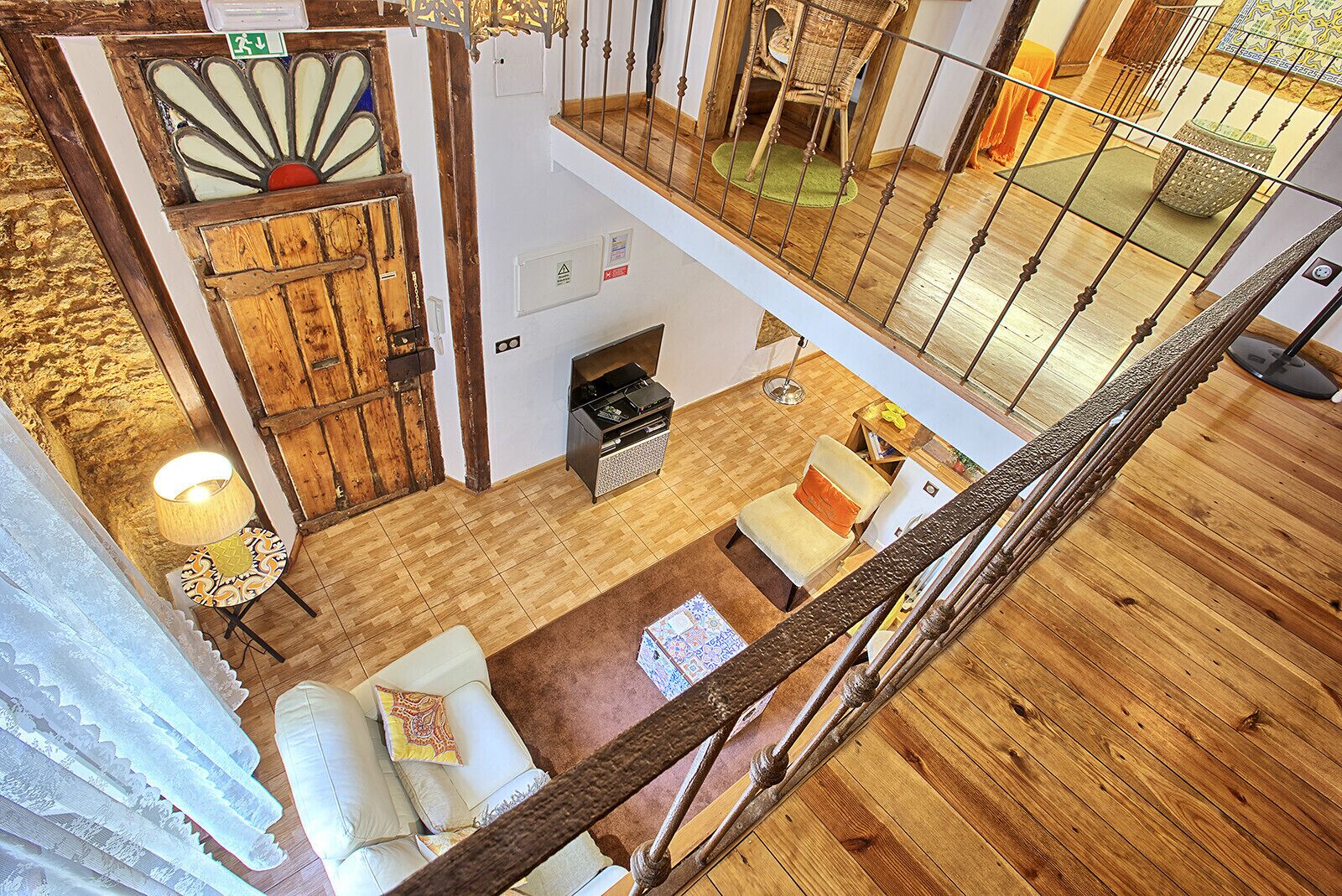 Un salón amplio con chimenea, piso de madera y techos altos.