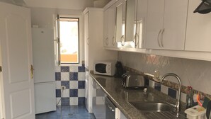 A kitchen with white cabinets, a granite countertop, a stainless steel sink, and a window with a view. - Viviendas Vacacionales vacation rental property. 3 bedroom private pool. Value (Callao Salvaje)