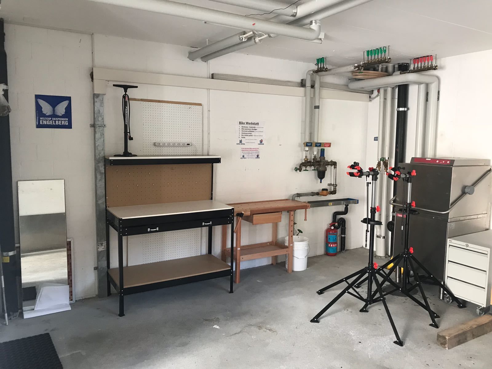 Een werkplaats met werkbanken, gereedschap en een brandblusser.