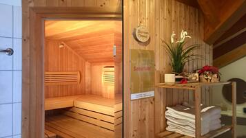 Un sauna en bois, doté de bancs et d’une pancarte indiquant « Sonnen Dimmel ».