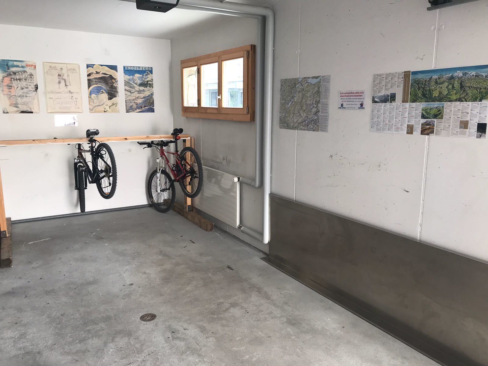 Un garaje con dos bicicletas, un banco de madera y una ventana.