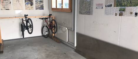 Un garaje con dos bicicletas, un banco de madera y una ventana.