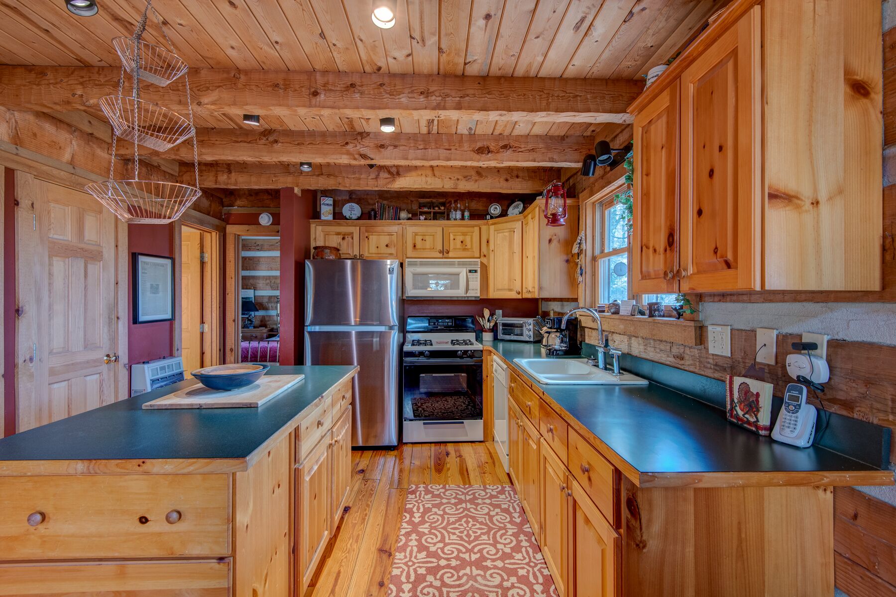 A modern kitchen with wooden cabinets, stainless steel appliances, and a central island.