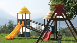 A playground with slides and swings. - Goldenlake Apartment (Perledo)