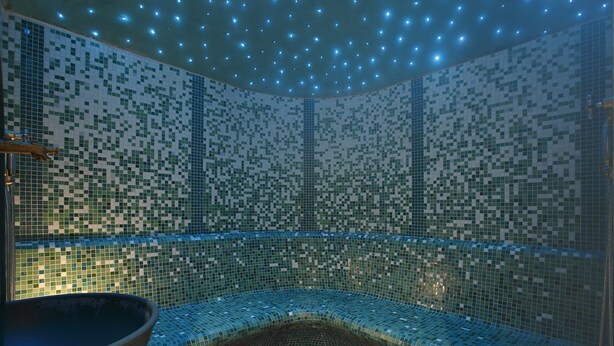 A modern, dimly lit room with a mosaic-tiled wall and ceiling, a large bowl in the foreground, and a small, tiled floor area. - Villa Emma (Tre Ville)
